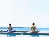 プールサイドでの朝ヨガの画像